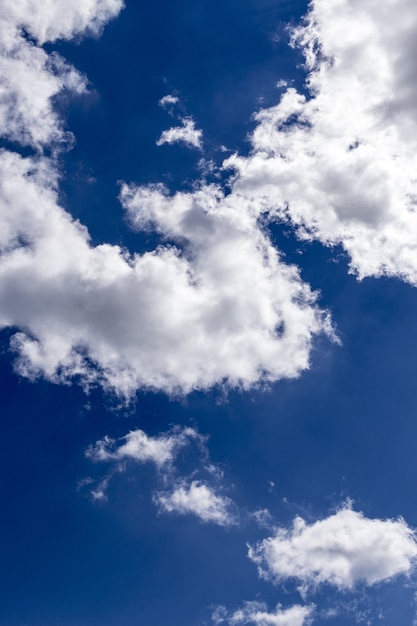 Вертикальная съемка красивого голубого неба с захватывающими дух белыми облаками