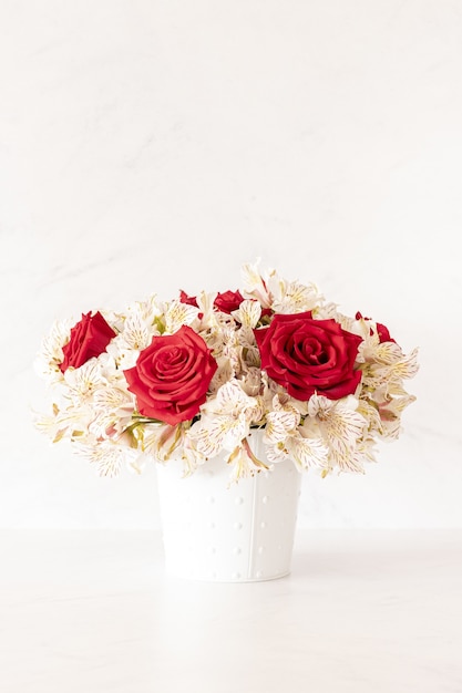 Vertical shot of a beautiful bouquet with red roses and lily flowers in a box