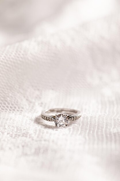 Vertical shot of a beautiful diamond ring on a white surface