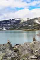 Foto gratuita colpo verticale di un bellissimo lago circondato da alte montagne rocciose in norvegia