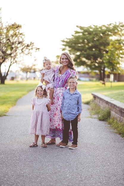 Vertical shot of a beautiful mom with her adorable kids in a park