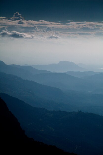 아름다운 산맥의 세로 샷과 이른 아침에 흐린 하늘