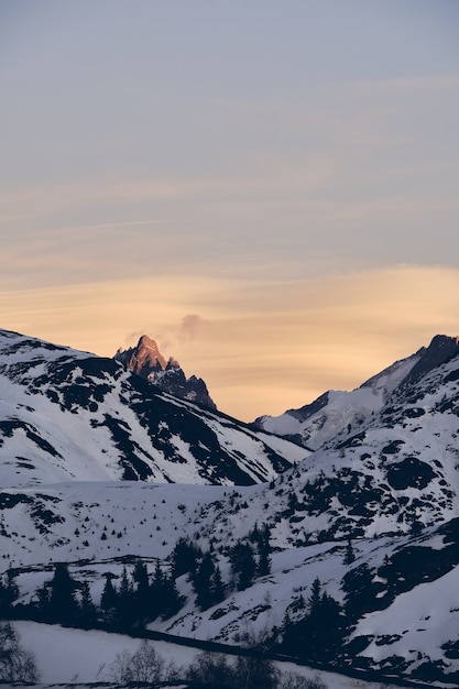Free photo vertical shot of beautiful snow covered alpine mountain