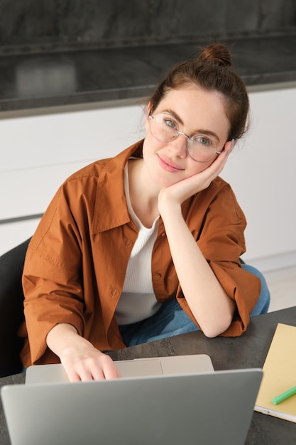 vertical-shot-beautiful-woman-working-from-home-student-doing-homework-kitchen-using-laptop_1258-203003.jpg