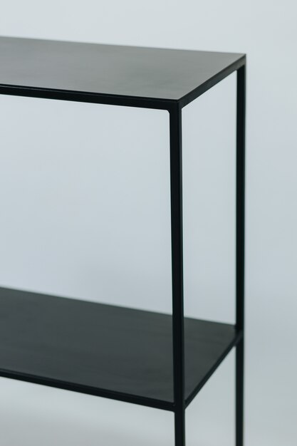 Vertical shot of a black metal shelf made with minimalistic design