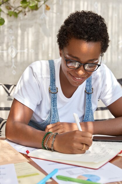 vertical shot of black woman has tender smile, curly short hair