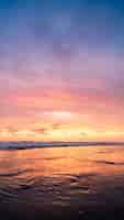 Foto gratuita colpo verticale di uno specchio d'acqua con il cielo rosa durante il tramonto. perfetto per uno sfondo.