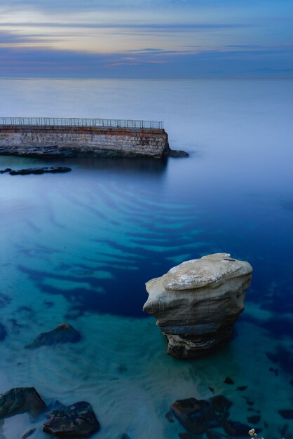 石垣のある息を呑むような青く澄んだ海の垂直ショット