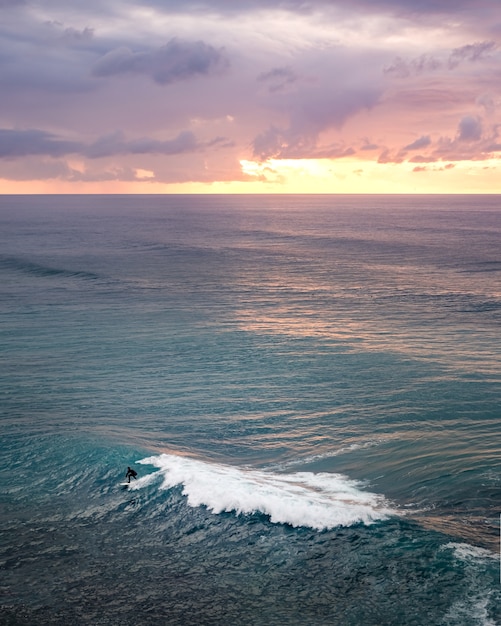 海に沈む息を呑むような夕日の風景の垂直ショット