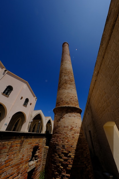 Vertical shot of a brick tower near a mention on a sunny day