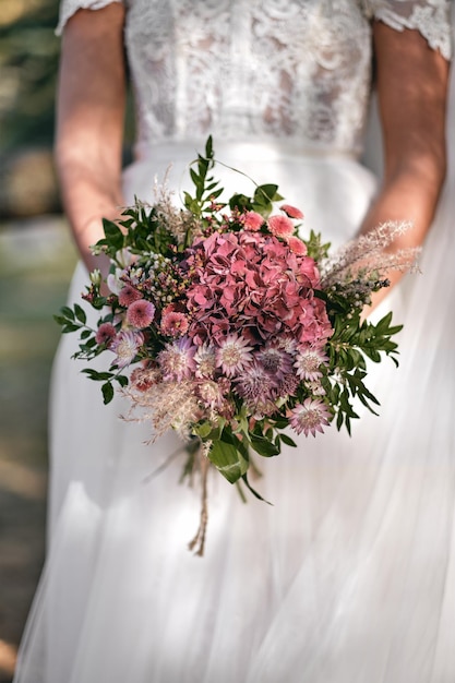 Vertical shot of a bride holding a bouquet of flowers