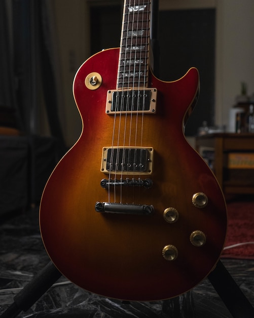 Vertical shot of a brown acoustic guitar on the ground