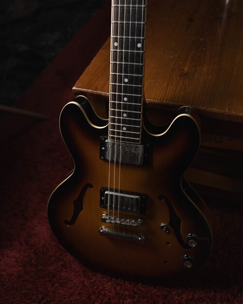 Vertical shot of a brown acoustic guitar on the ground