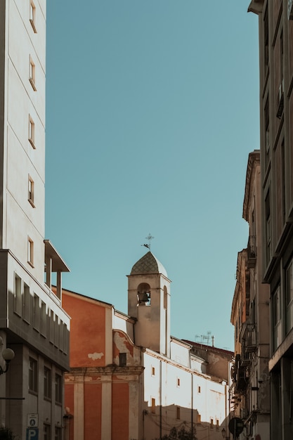 Vertical shot of buildings in the bell tower in the distance and a blue sky