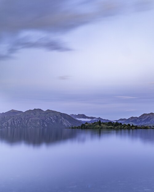 Вертикальный снимок спокойного озера с отражениями на горном хребте