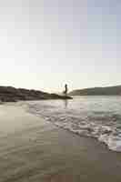 Foto gratuita colpo verticale di una donna attraente caucasica su una spiaggia in spagna