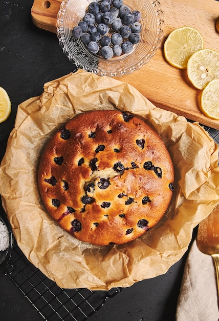 Foto gratuita colpo verticale di una torta di ciliegie con zucchero in polvere e ingredienti