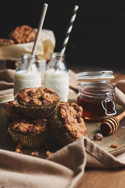 Vertical shot of chocolate muffins with honey and milk