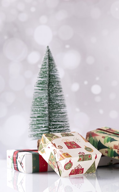 Vertical shot of Christmas gift boxes and small tree