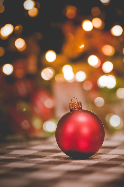 Vertical shot of a Christmas ornament by the blurred lights