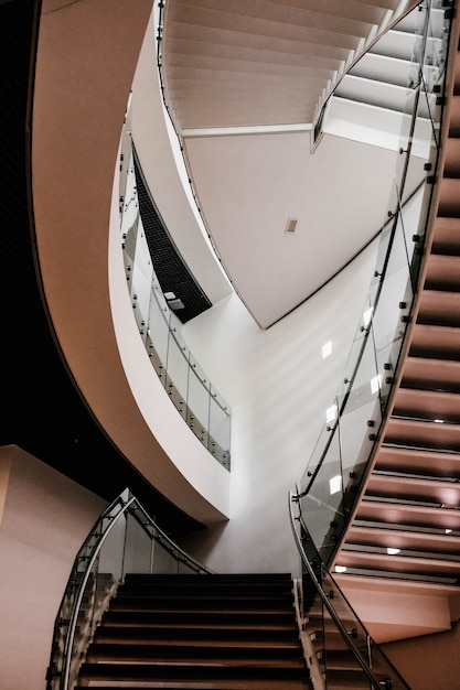 Вертикальная съемка бетонной лестницы внутри здания с включенным освещением