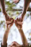 Free photo a vertical shot of a couple holding hands with a blurred background