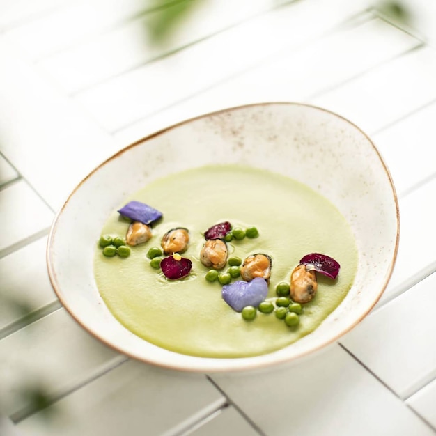 Foto gratuita ripresa verticale di una zuppa cremosa di verdure su un tavolo di legno bianco