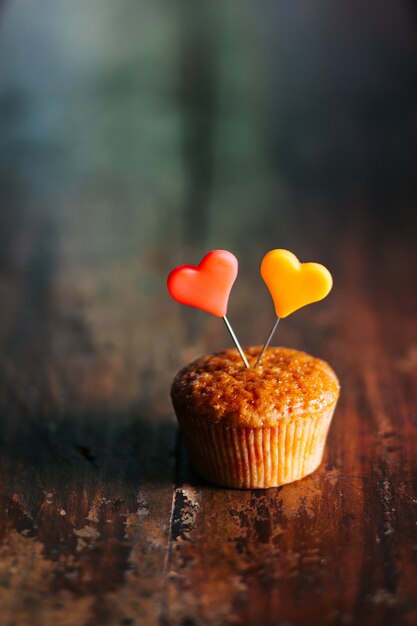 Vertical shot of a cupcake with colorful hearts on it