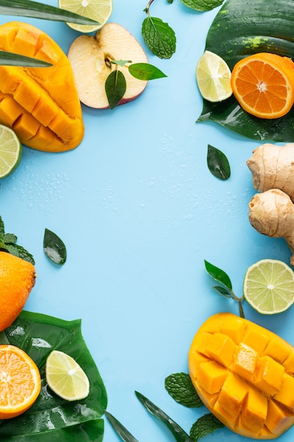 Vertical shot of cut fruits on a light blue background