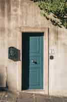 Free photo vertical shot of a cute blue door on a stone building