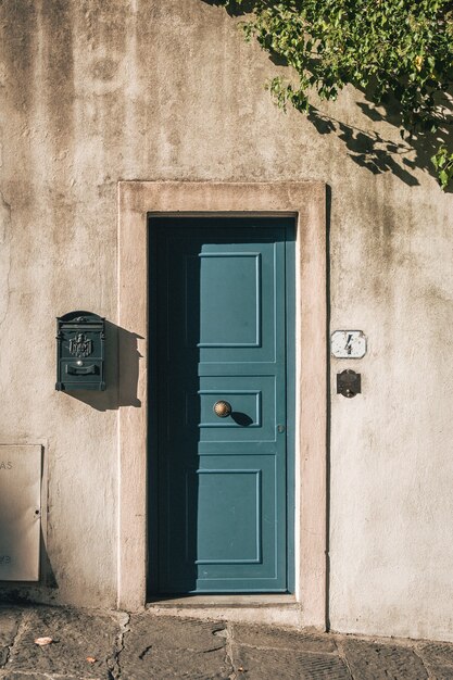 Vertical shot of a cute blue door on a stone building