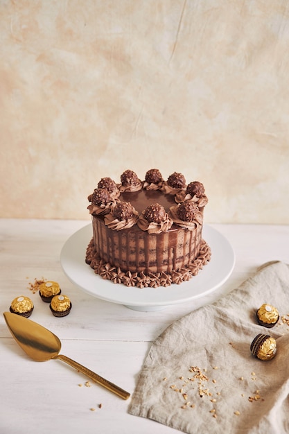 Vertical shot of a delicious chocolate cake on a plate next to some pieces of chocolate