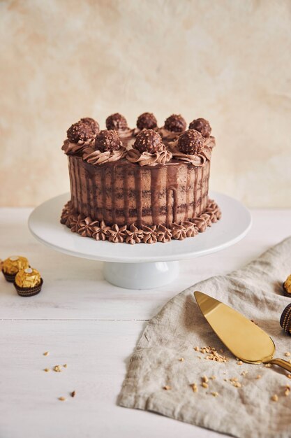 Vertical shot of a delicious chocolate cake on a plate next to some pieces of chocolate