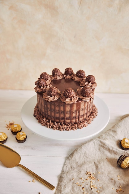 いくつかのチョコレートの横にあるプレート上のおいしいチョコレートケーキの垂直ショット