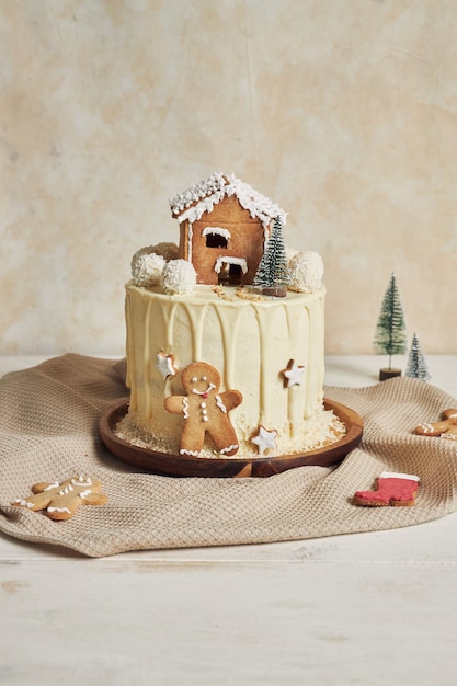 Вертикальный снимок вкусного рождественского торта с пряничными украшениями и кокосовыми миндальными шариками
