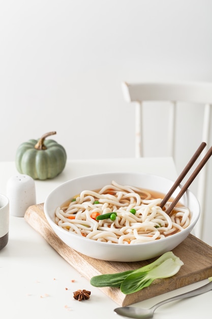 Foto gratuita colpo verticale di deliziosa zuppa di noodle in minimalista estetica interna domestica