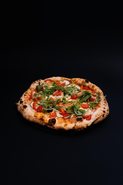 Vertical shot of a delicious pizza on a black surface