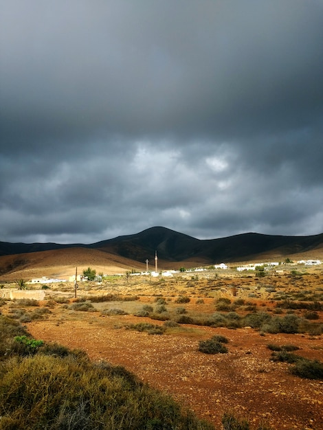 スペイン、フェルテベントゥラ島の荒天前の影の乾燥した谷と丘の垂直ショット