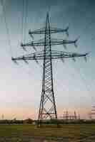 Free photo vertical shot of an electric pole under a blue cloudy sky