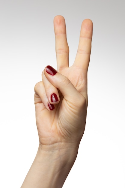 Vertical shot of a female hand with a peace hand sign