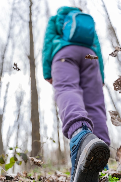 Foto gratuita ripresa verticale di una viandante che cammina attraverso la foresta