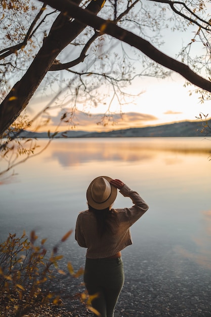 Free photo vertical shot of a female standing on the bay enjoying the view in motueka, new zealand