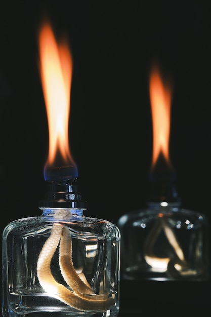 Free photo vertical shot of the flames of scent diffusers in the dark