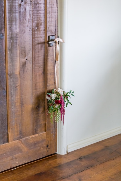 ドアの取っ手からぶら下がっている花の装飾の垂直ショット