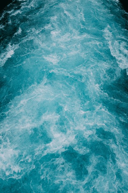 Vertical shot of the foamy waves of water in the sea