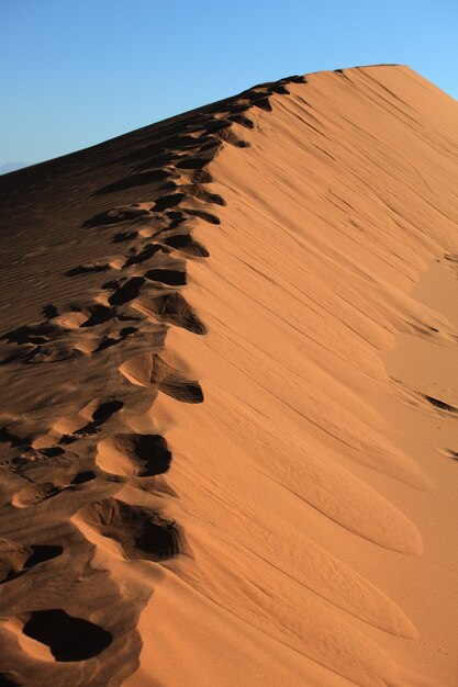 Vertical shot of footprints on sand dunes in Xijiang, China