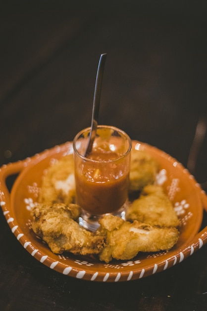 Colpo verticale di cibo fritto e salsa al centro