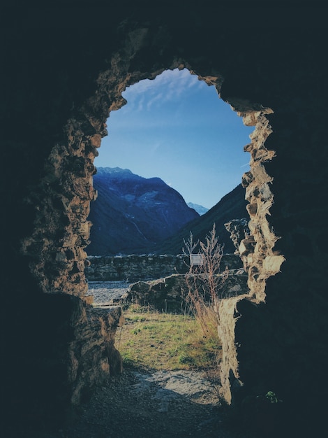 Vertical shot from the inside of a cave with a mountain 