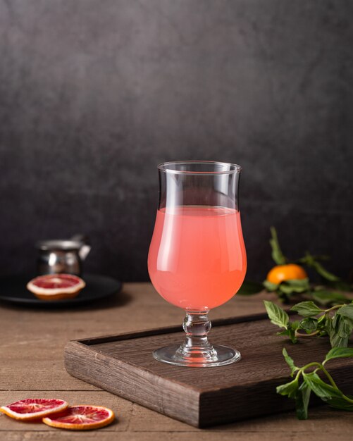 Vertical shot of a glass of grapefruit juice and mint leaves on the table