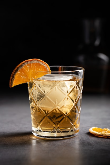 Vertical shot of a glass of whiskey decorated with a slice of dried orange